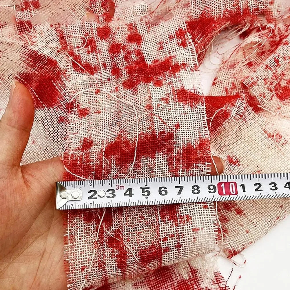Roll of Halloween horror bandage in bloody red colour with a frayed end, showing its 8cm width and cloth-like polyester texture.