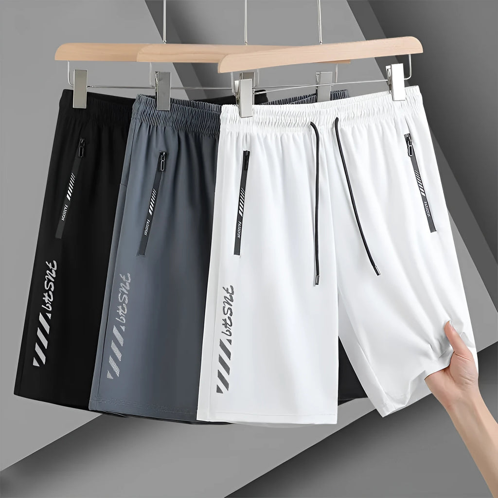 Man wearing black loose-fit quick-drying nylon sports shorts with a five-inch length.