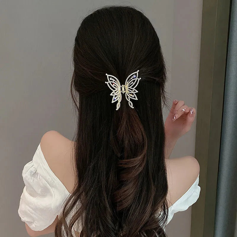 Butterfly-shaped hair clip with metal alloy construction and decorative rhinestone or pearl elements