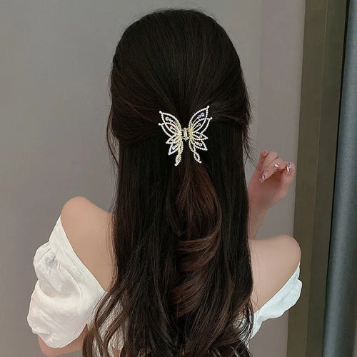 Butterfly-shaped hair clip with metal alloy construction and decorative rhinestone or pearl elements