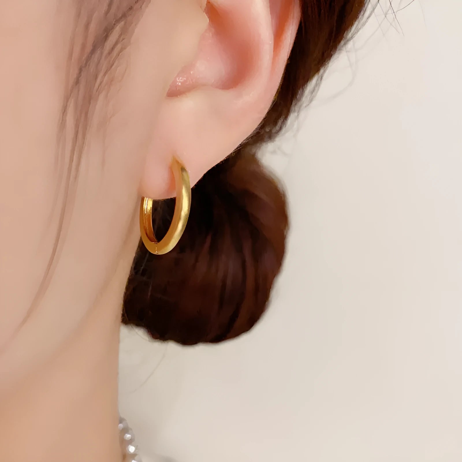 Women's simple geometric round copper ear clips with real gold plating in gold and silver colours showing eyelet design detail