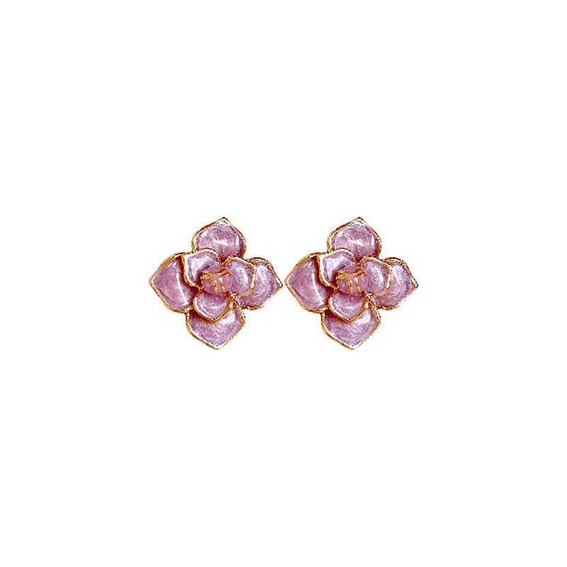 Close-up of a pair of purple and gold flower stud earrings with a textured oil-spot glaze finish.