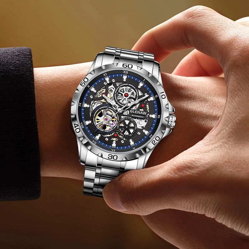 Silver automatic mechanical watch with hollow-out design showing luminous dial and stainless steel strap