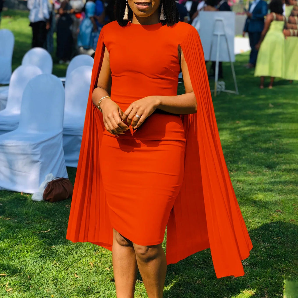 A model wearing a yellow high-waist evening gown with long sleeves and a pleated floor-length skirt.