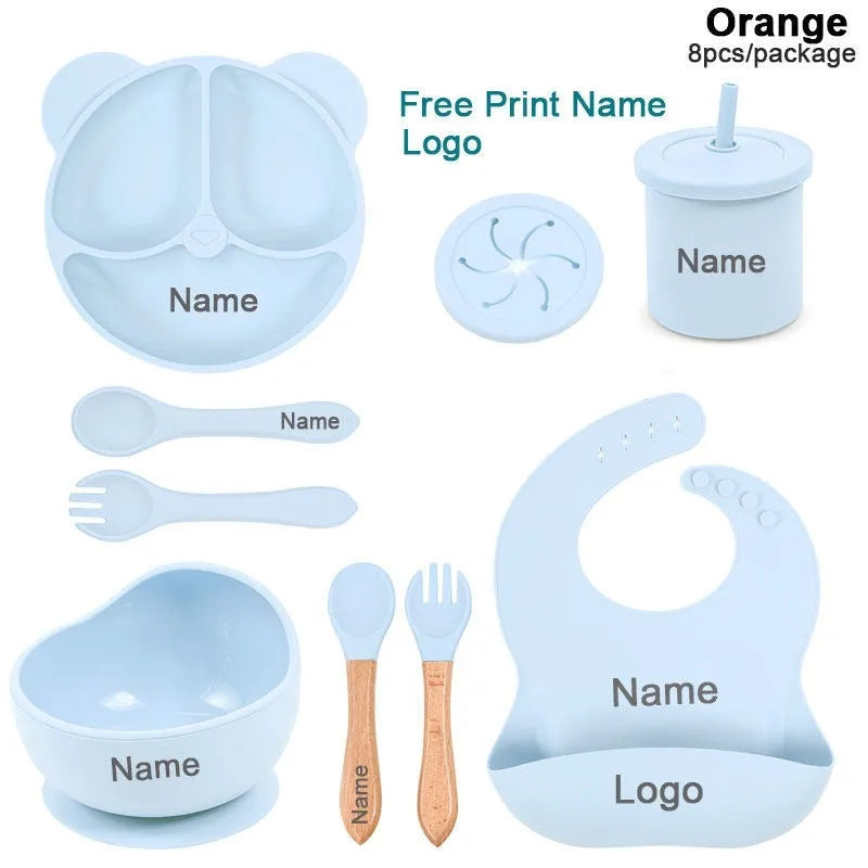 Children's silicone tableware set with cat ear cup in beige, blue and other colours on a table