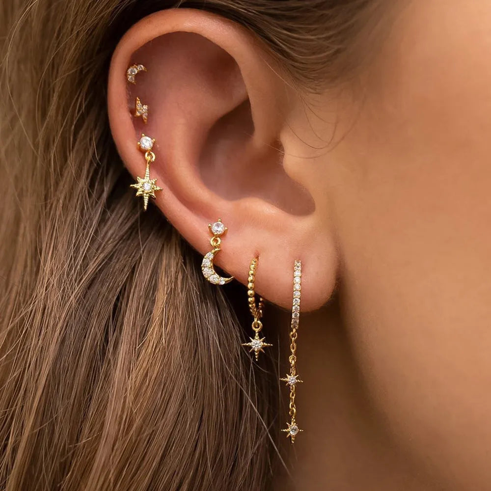 Six pairs of gold chain tassel earrings with zircon studs in display layout