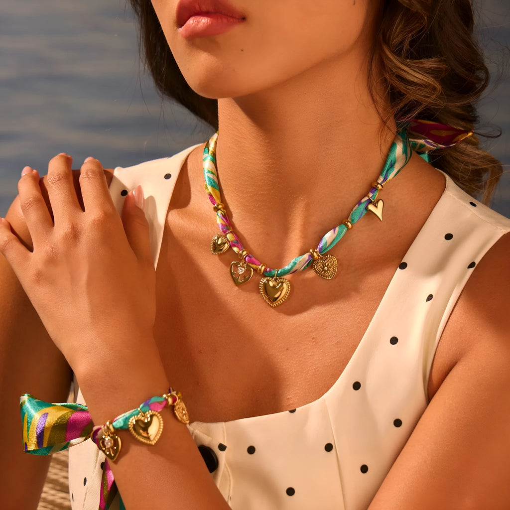 Gold geometric pendant necklace and bracelet set with adjustable chain on white background