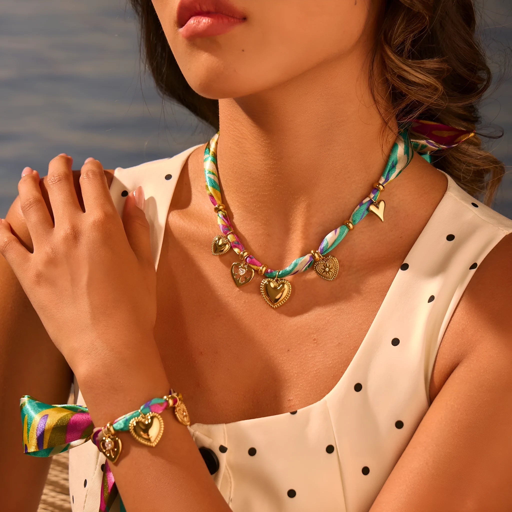 Gold geometric pendant necklace and bracelet set with adjustable chain on white background