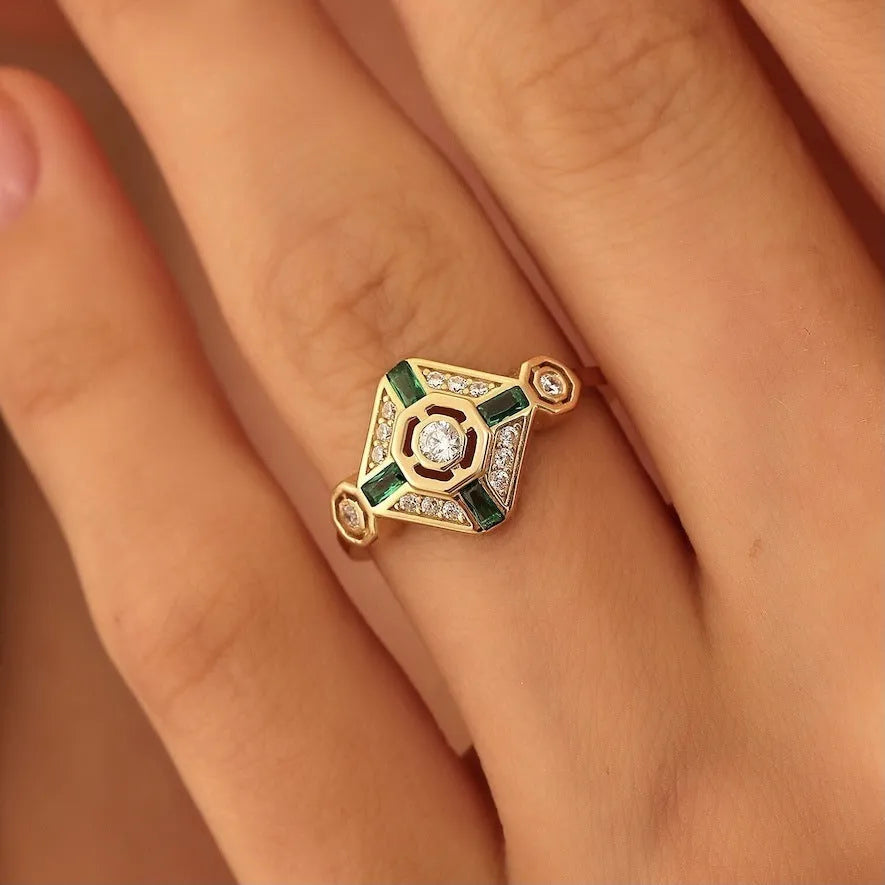 Square-shaped women's ring with a green emerald gemstone on a geometric band.