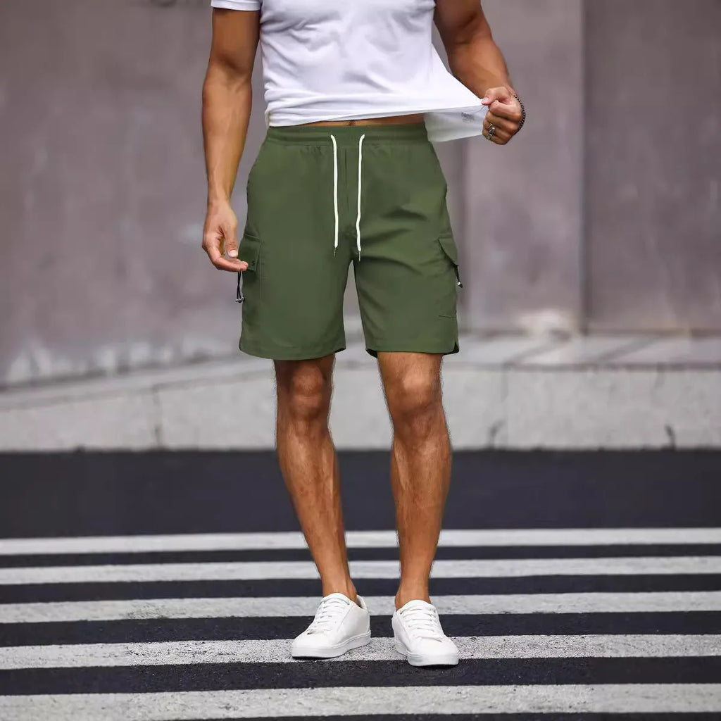 Man wearing loose fit army green straight leg workwear shorts made from cool silk cotton fabric.