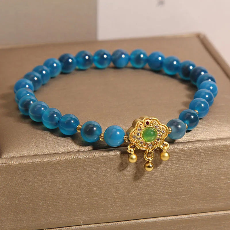 Blue sugar heart agate safety lock pendant on a crystal women's bracelet with alloy-set stones.