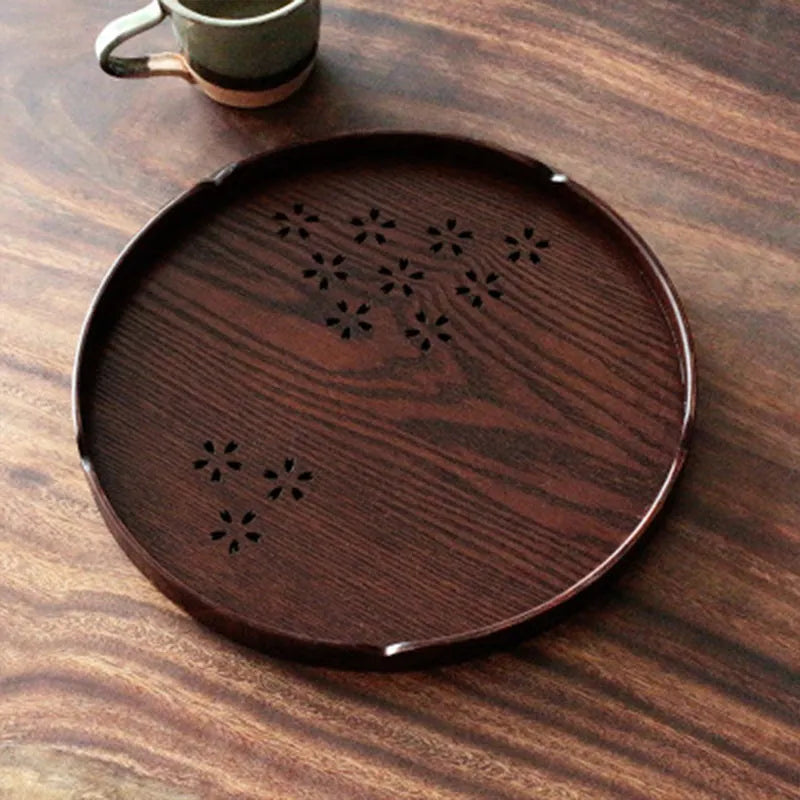 Twelve wooden dessert plates with hollow cherry blossom pattern arranged in set