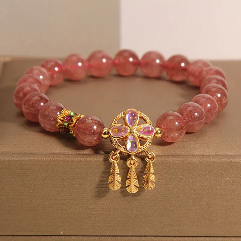 Women's strawberry quartz crystal bracelet with four leaf dream catcher pendant.