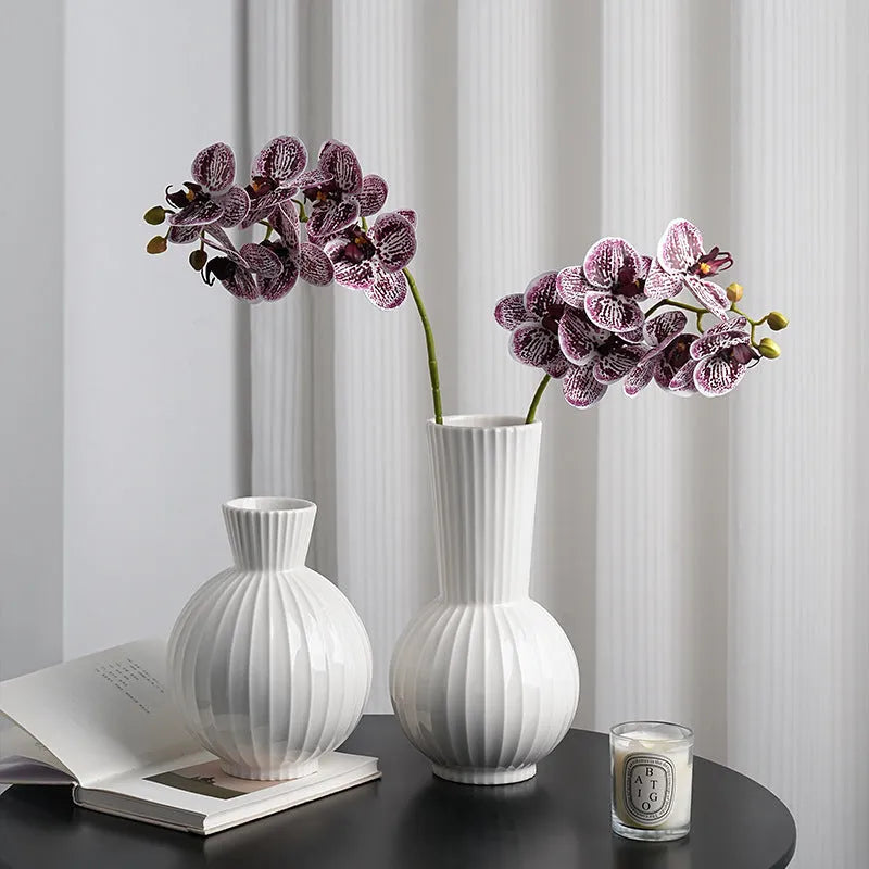 White ceramic ball vase with blue stripes on wooden table
