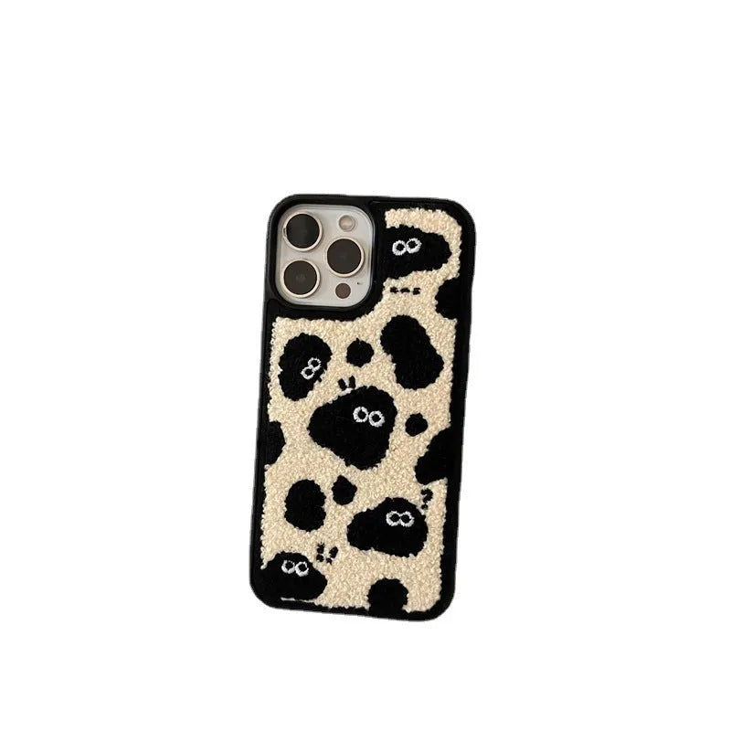 Black plush fairy funny back cover phone case for iPhone models on a table.