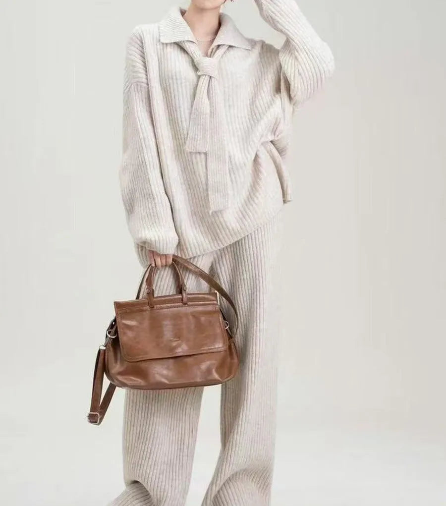 Beige sweater suit two-piece set with a knitted top and casual trousers on a hanger.