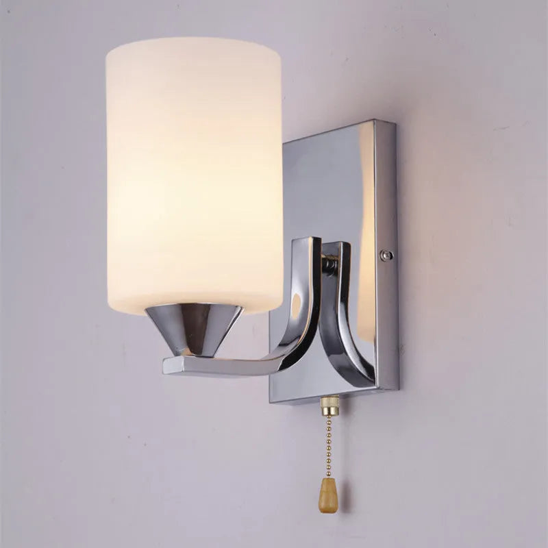 Modern chrome and glass wall lamp with single head design showing glass lampshade and metallic finish
