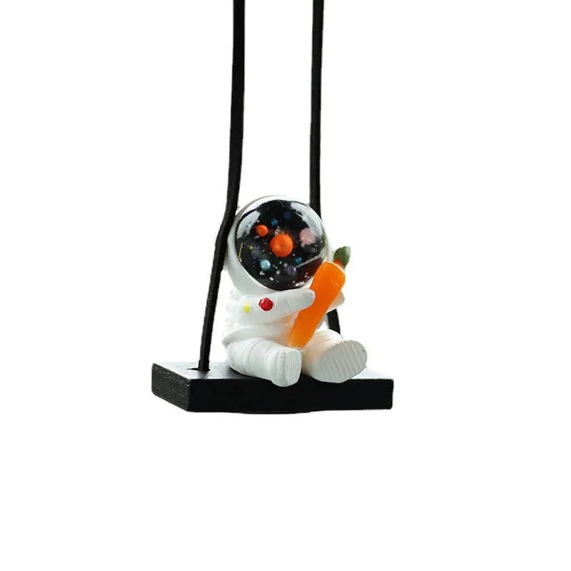 Resin astronaut car pendant showing five cartoon designs including telescope and flag-holding astronauts