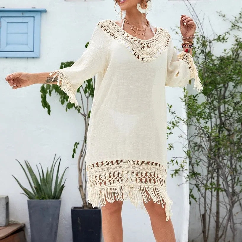 Apricot coloured crocheted knitted patchwork beach dress on a hanger, showing mid-length skirt and half sleeves.