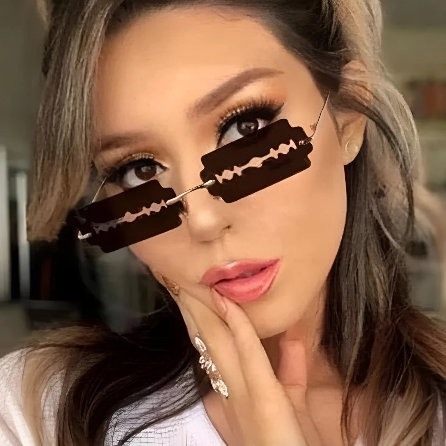 Women's metal rimless frameless sunglasses with gold frame and blue lens on display