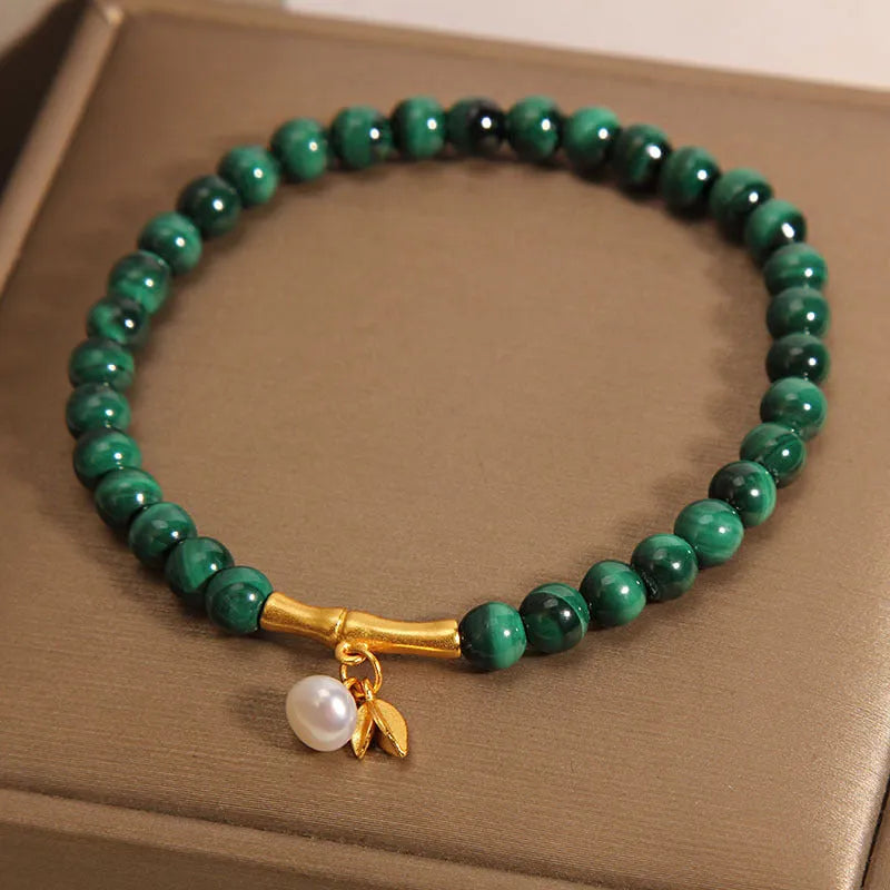 A women's adjustable bracelet made of white crystal with a lucky bamboo charm on the wrist.