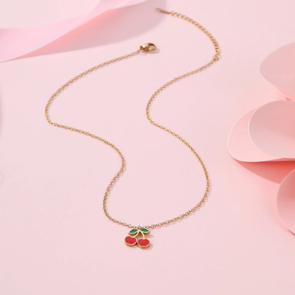 Four-piece stainless steel cherry jewellery set with gold plating: necklace, bracelet, earrings, and ring.