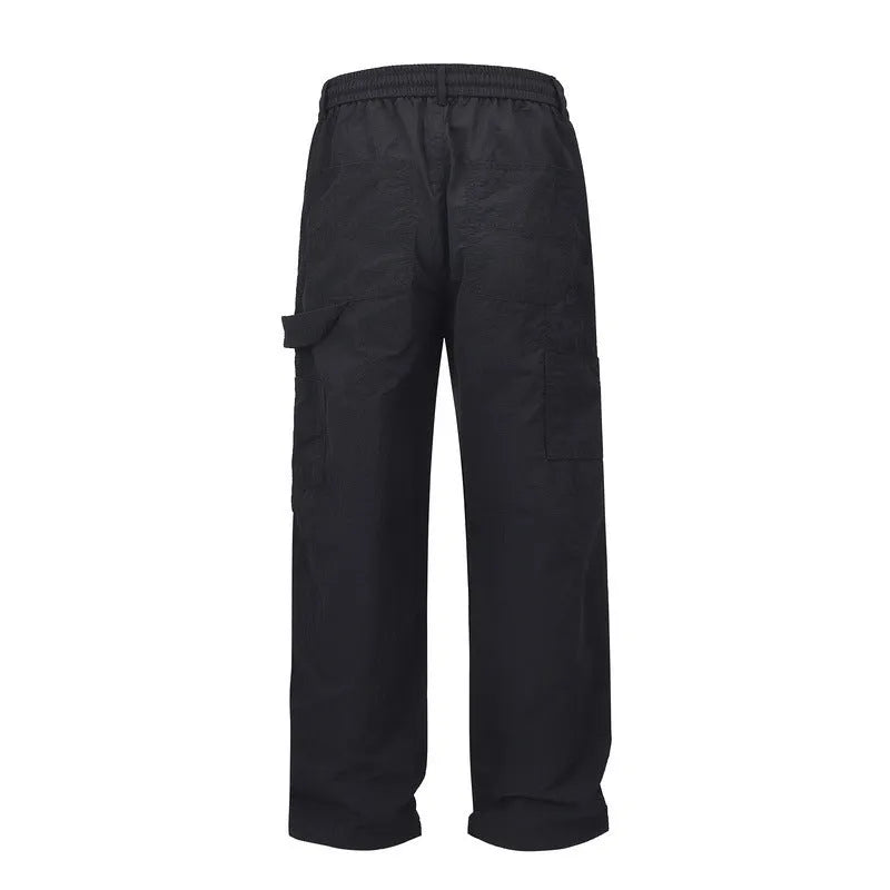 Black baggy men's paratrooper pants with a drawstring waist and three-dimensional cutting.