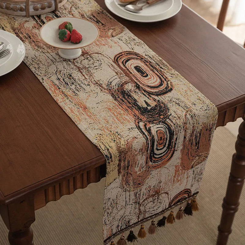 Nordic jacquard table runner with tassel trim in dark blue striped pattern laid on a wooden table.
