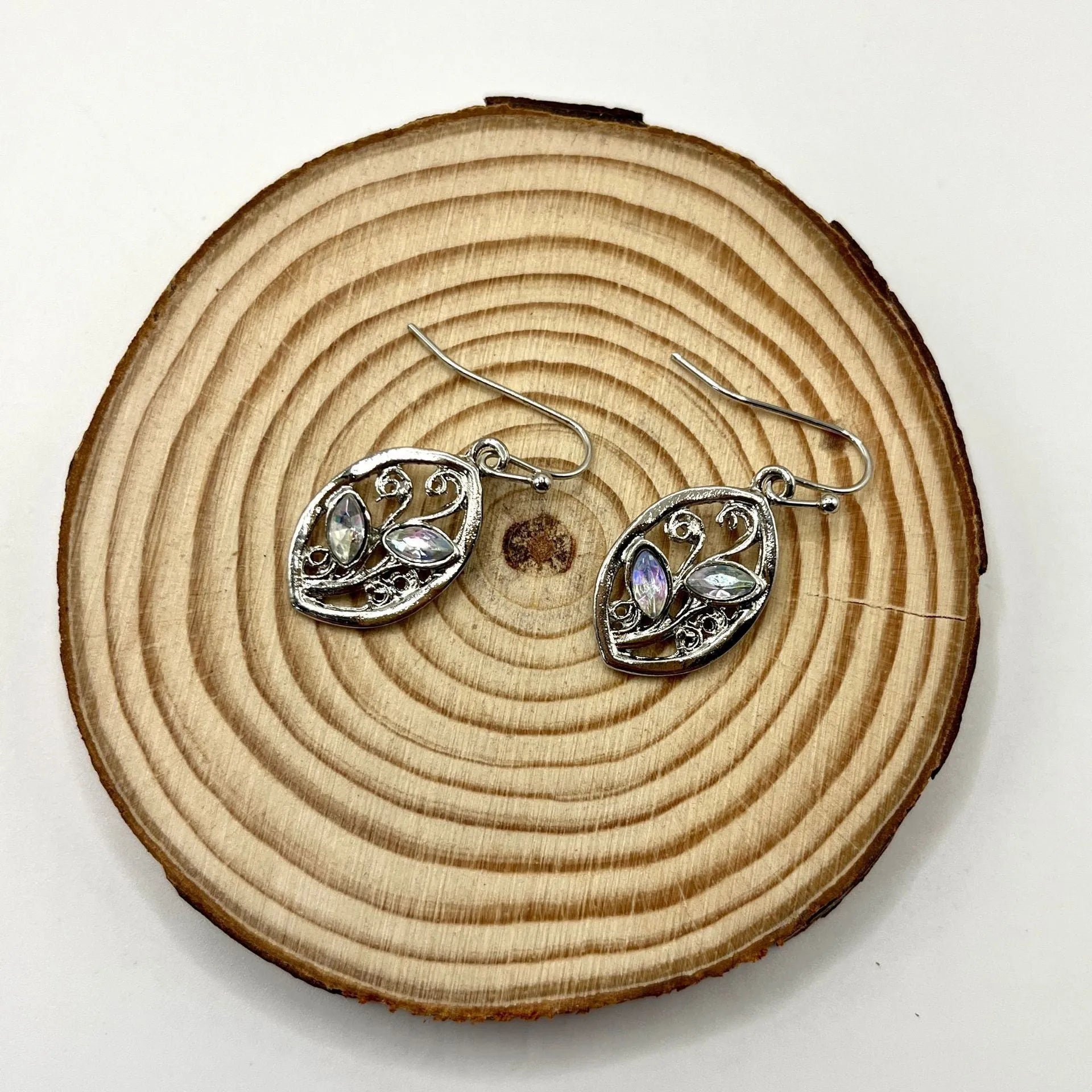 Silver-coloured alloy earrings shaped like a leaf with colourful moonstone stones embedded in the design.