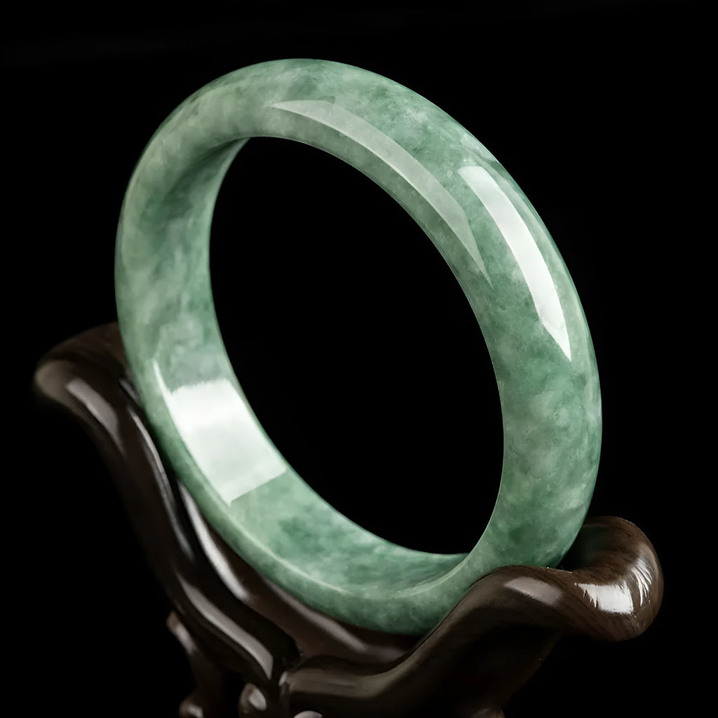 Natural deep pea green emerald stone bracelet on a wrist, showing its simple band design.