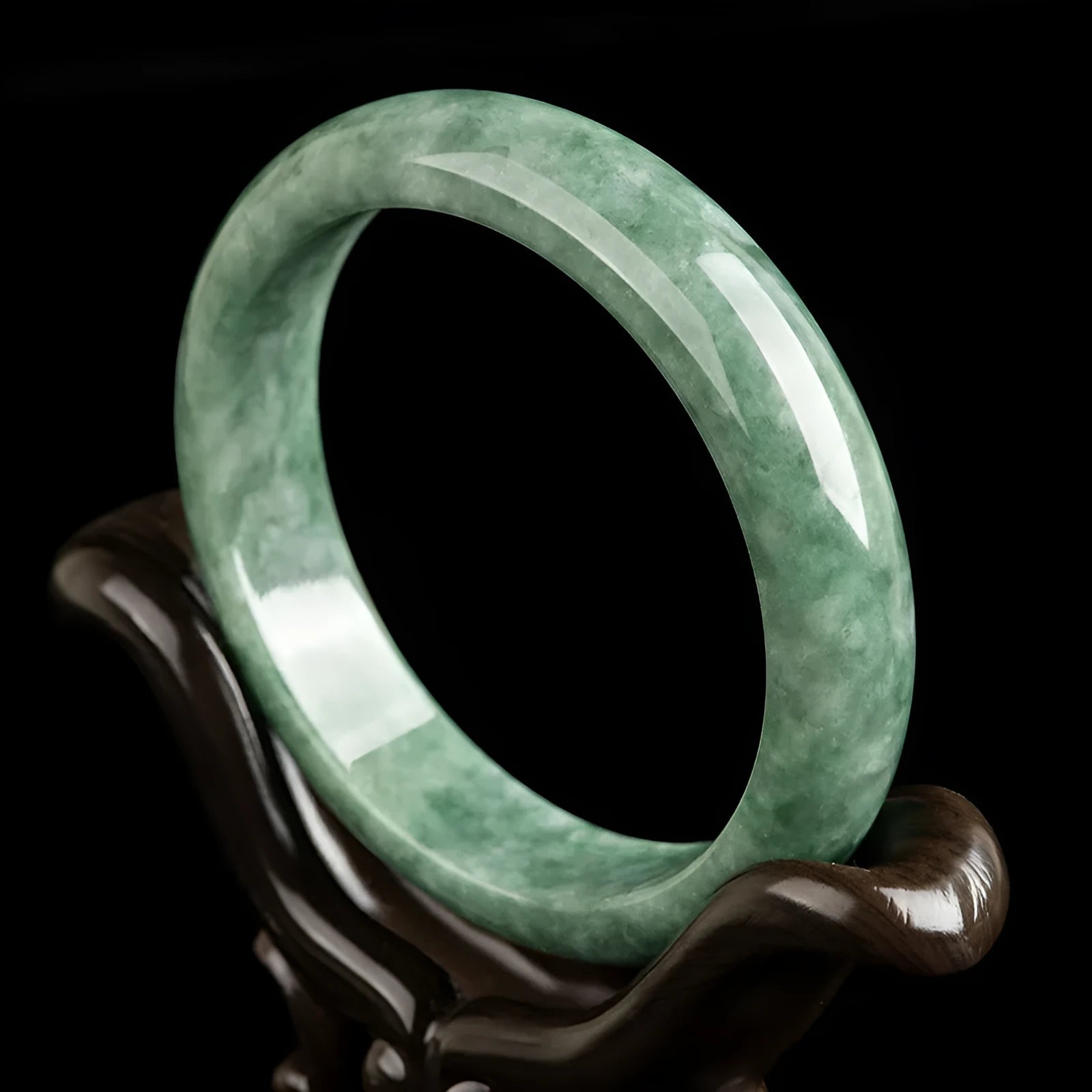 Natural deep pea green emerald stone bracelet on a wrist, showing its simple band design.