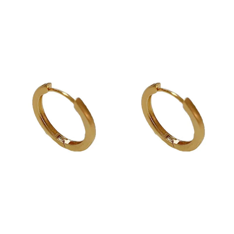 Women's simple geometric round copper ear clips with real gold plating in gold and silver colours showing eyelet design detail