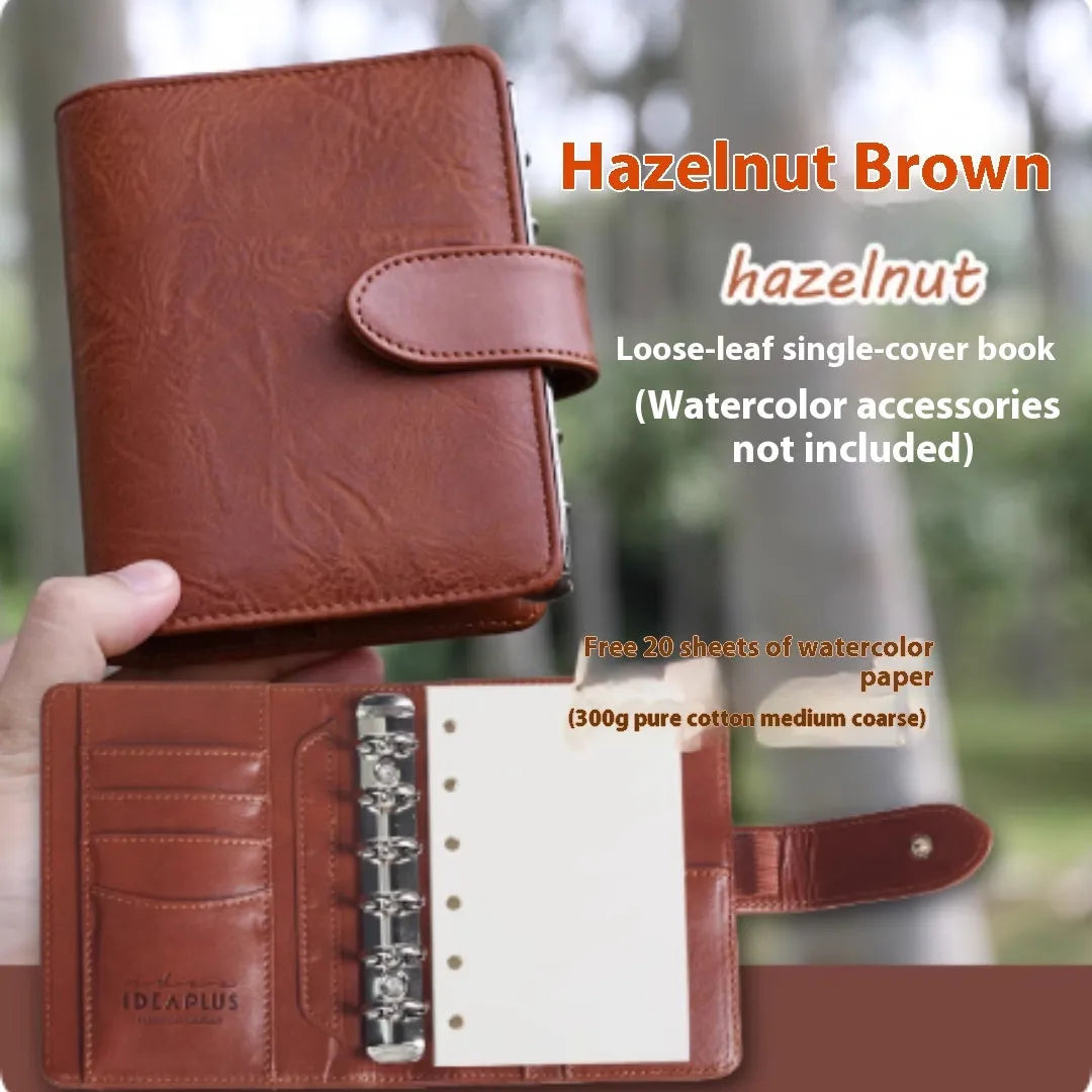 A7 format loose-leaf watercolour notebook in green, open to show removable pages suitable for painting.