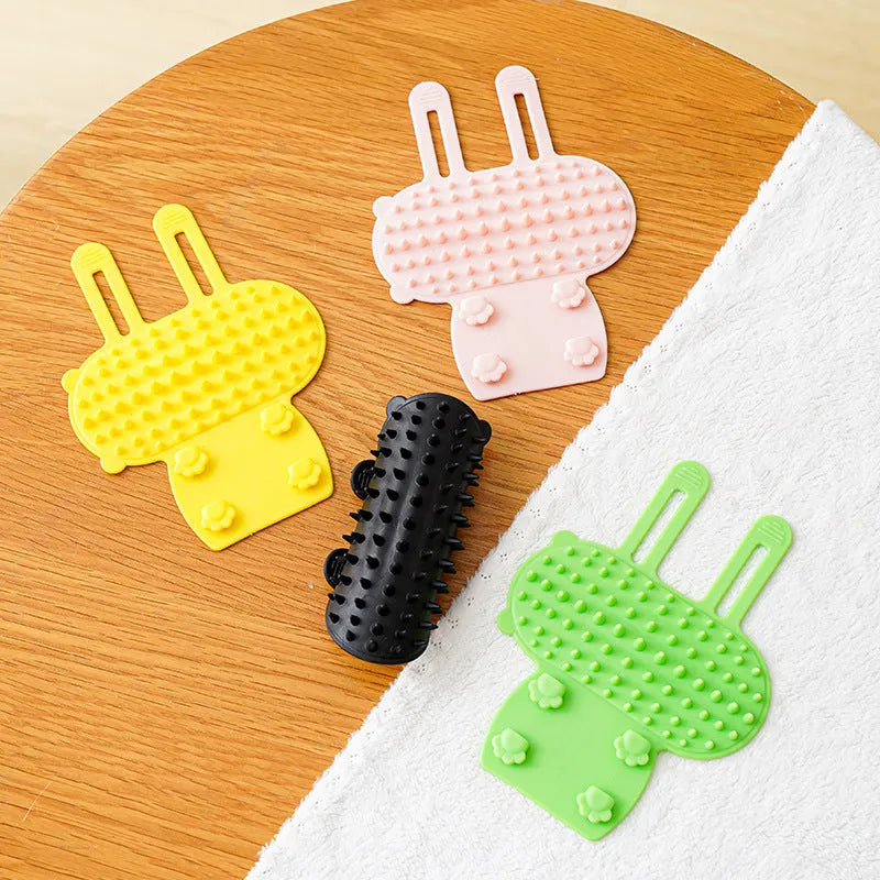 Silicone cat grooming brush mounted on table leg with adjustable strap, available in four colours