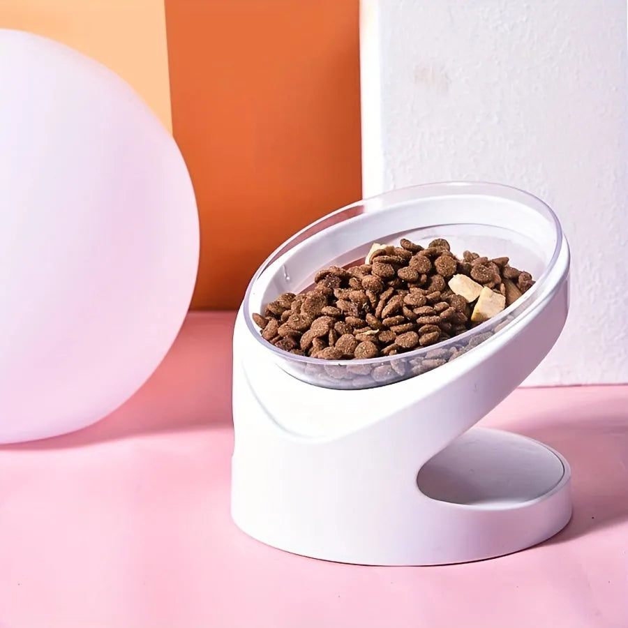Clear plastic elevated cat food bowl with tilt design on white surface