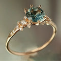 Gold geometric ring with claw settings holding zircon stones, showing chamfered square patterns on band
