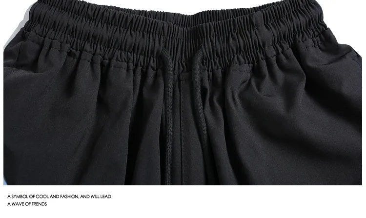Man wearing loose-fit black quick-dry sports shorts with an elastic waistband.