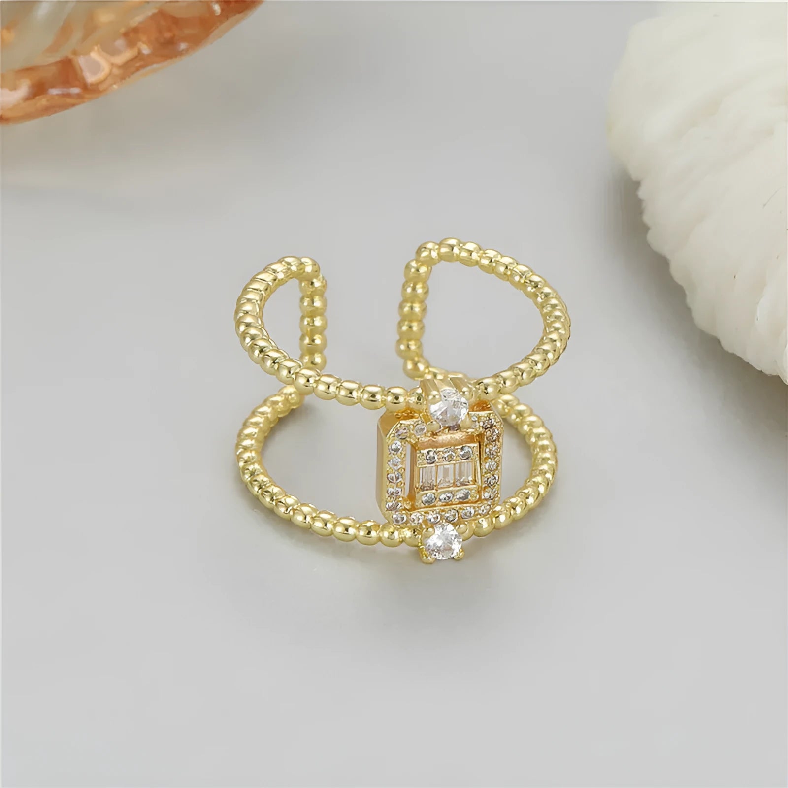 Gold-plated copper open ring with an asymmetric U-shape and adjustable opening.