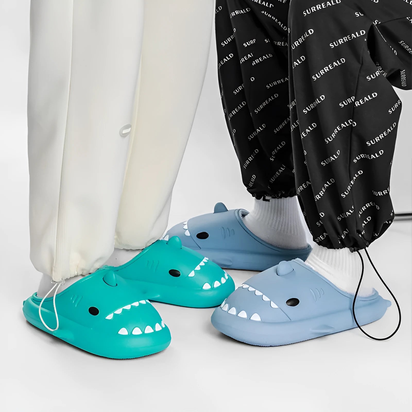 Winter soft bottom household couple EVA cartoon shark cotton slippers in blue, grey, pink on a floor