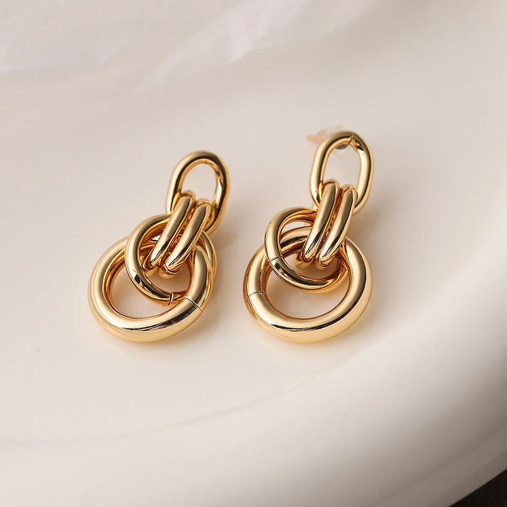 A pair of gold geometric earrings for women with an irregular shape, made from copper.