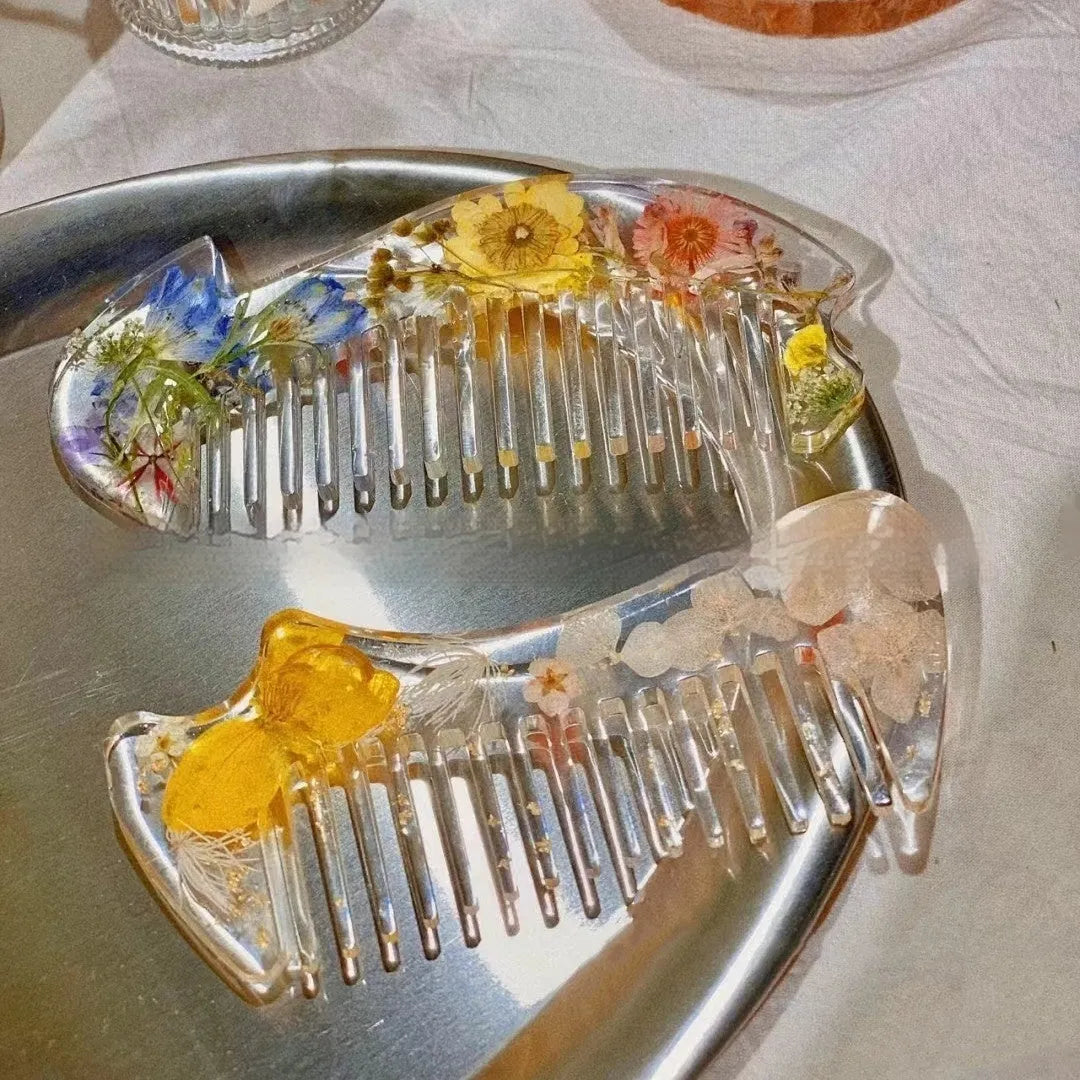 Small glossy resin hair comb with a reflective mirror finish, shown in one of three colour options.