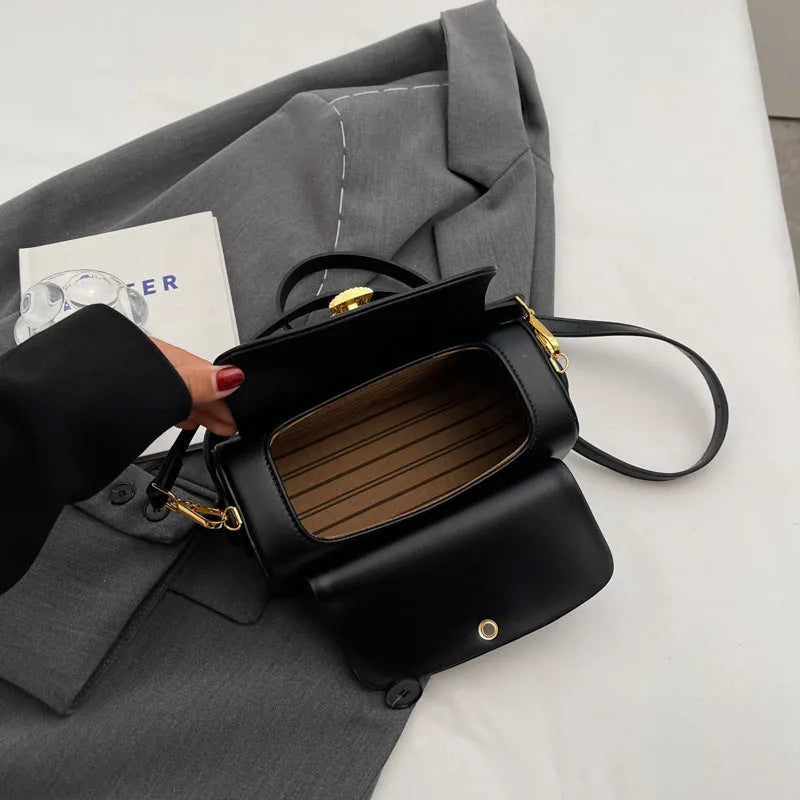 Women's personalised black PU leather shoulder messenger bag with letter detail and stitching.