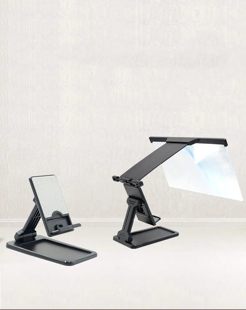 Black folding mobile phone screen magnifier with detachable holder on a desktop.
