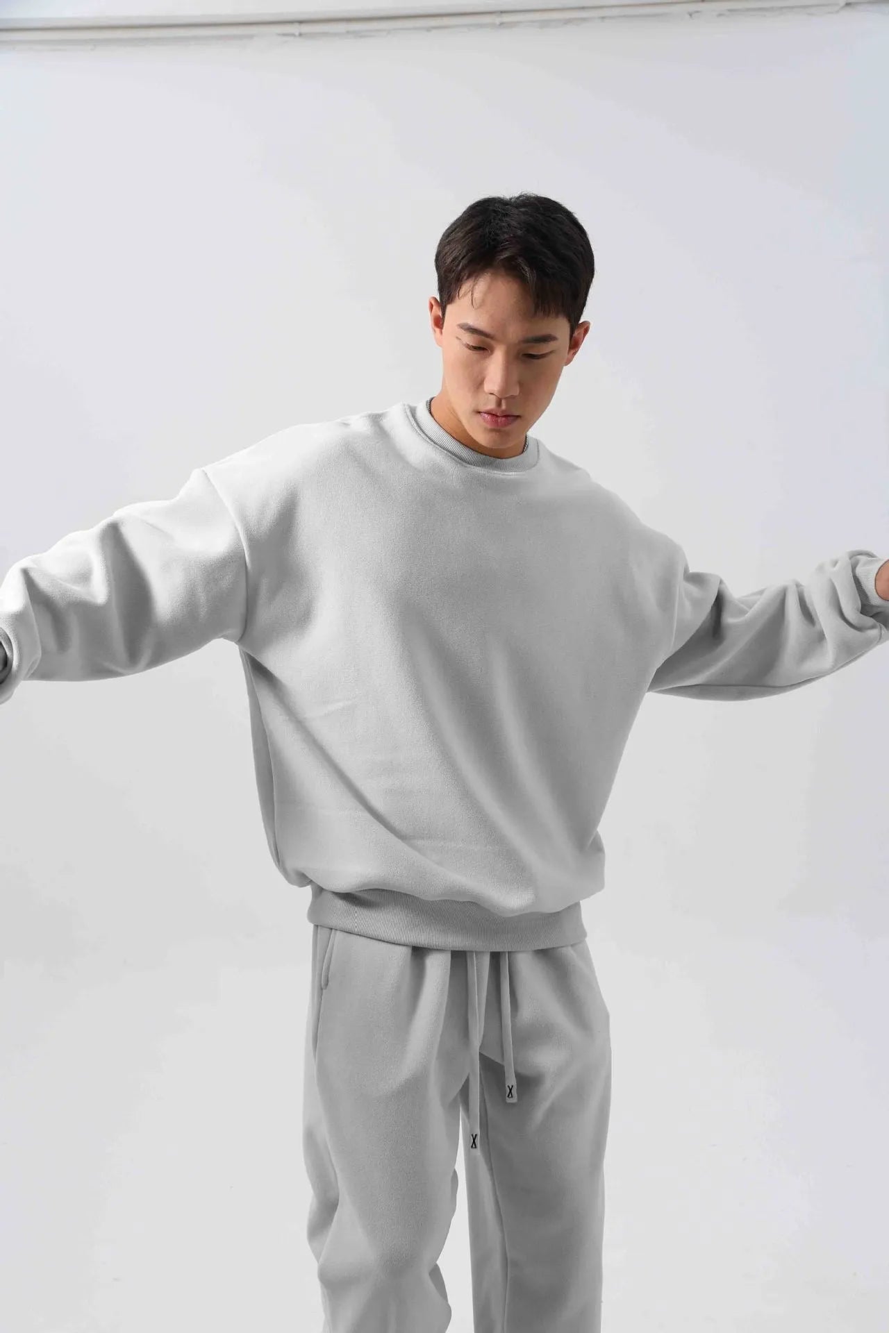Men's polar fleece tracksuit set showing crew neck top with padded trousers in winter sportswear style