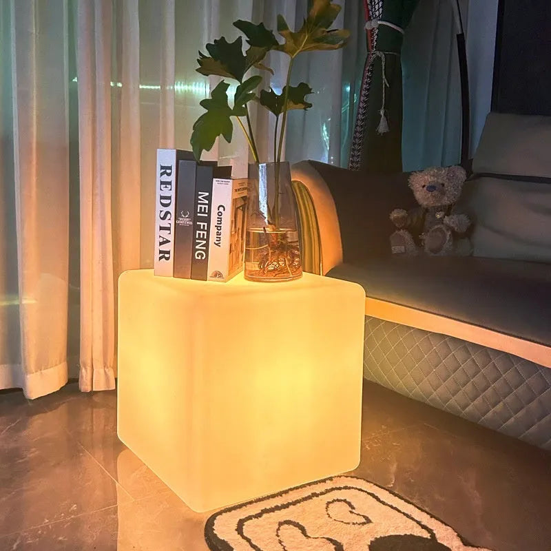 Modern white LED cube stool light outdoors, showing flat top and clean design.