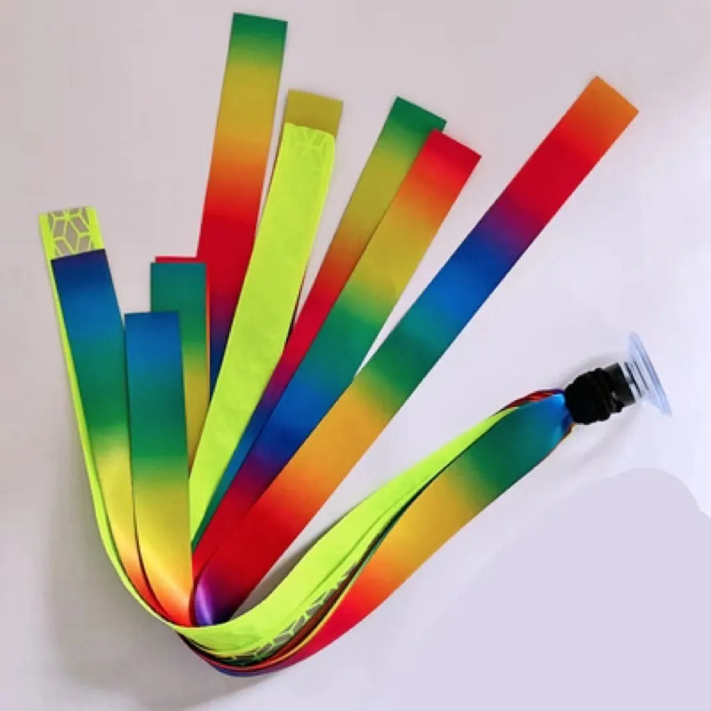 Colourful fabric helmet streamers for children's roller skating and ski helmets, shown in apricot, red, and grey.