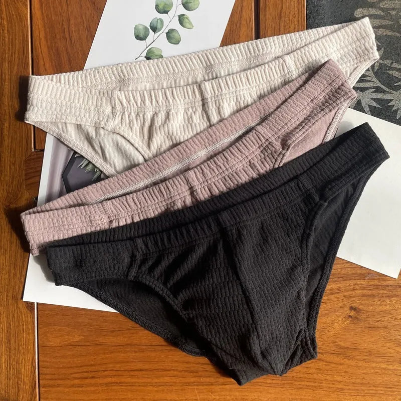 Men's solid colour cotton triangle briefs in apricot, shown from the front on a mid-waist fit model.