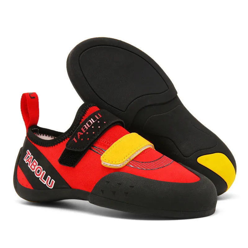 Beginner rock climbing shoes with Velcro straps and a coloured rubber sole on a climbing hold.