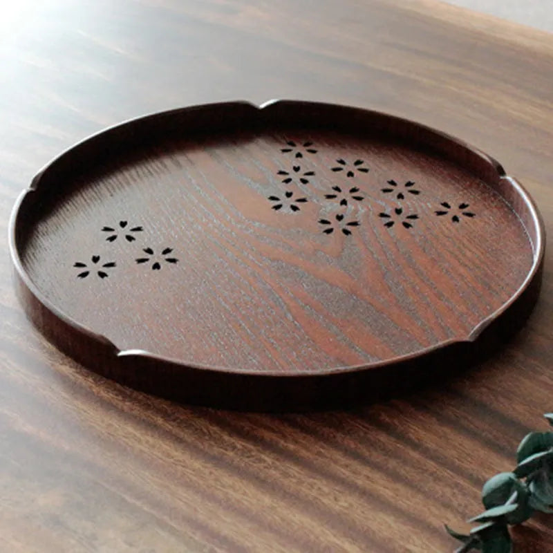 Twelve wooden dessert plates with hollow cherry blossom pattern arranged in set