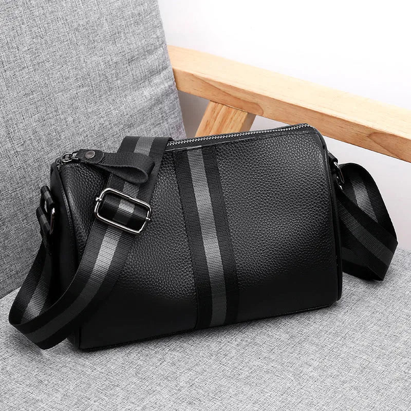 Black genuine leather crossbody bag with one-shoulder strap showing interior polyester lining